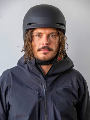 Ein Mann in einem Skianzug und Helm blickt in die Kamera. Ein Mann in einem Skianzug und Helm blickt in die Kamera.