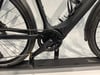 Teil eines schwarzen E-Bikes mit Kette und Pedal.