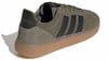 Zöld Adidas cipő fekete csíkokkal és áttetsző gumitalppal.