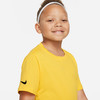 Ein Mädchen in einem gelben T-Shirt mit Nike-Logo auf dem Ärmel und einem weißen Haarband.