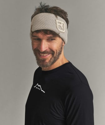 Ein Mann mit einem Stirnband und einem T-Shirt mit einem Berglöwen und dem ORTOVOX-Logo. Ein Mann mit einem Stirnband und einem T-Shirt mit einem Berglöwen und dem ORTOVOX-Logo.