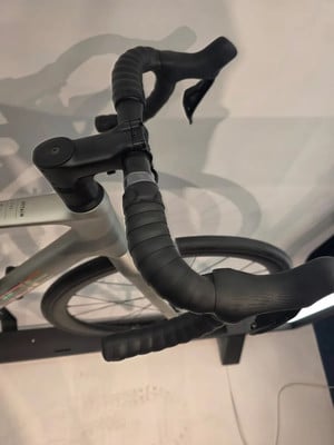 Detail eines Rennradlenkers mit Lenkerband und Bremshebeln.