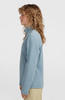 Frau in einem blauen Fleece-Pullover mit langen Ärmeln und Stehkragen.