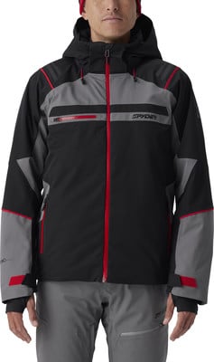 Ein Mann in einer schwarzen Skijacke mit grauen und roten Details und einer Mütze. Ein Mann in einer schwarzen Skijacke mit grauen und roten Details und einer Mütze.