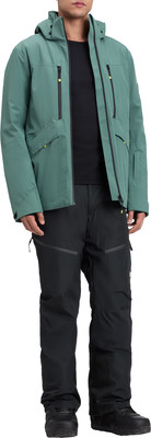 Ein Mann in einer grünen Jacke und schwarzen Skihose steht vor weißem Hintergrund. Ein Mann in einer grünen Jacke und schwarzen Skihose steht vor weißem Hintergrund.