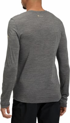 Ein Mann trägt ein dunkelgraues Langarmshirt mit einem goldenen Logo auf dem Rücken. Ein Mann trägt ein dunkelgraues Langarmshirt mit einem goldenen Logo auf dem Rücken.