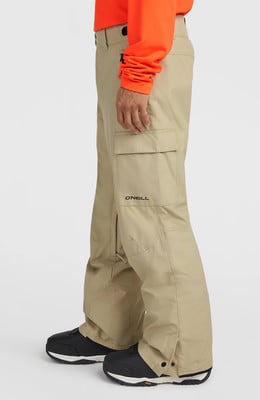 Ein Mann in beige Skihose mit orangefarbener Jacke und schwarzen Stiefeln. Ein Mann in beige Skihose mit orangefarbener Jacke und schwarzen Stiefeln.