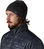 Ein Mann in einer schwarzen Mütze und einer gesteppten Jacke mit Patagonia-Logo.