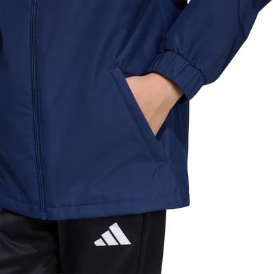 Detail einer Jacke mit einer Hand in der Tasche und einem Adidas-Logo auf der Hose. Detail einer Jacke mit einer Hand in der Tasche und einem Adidas-Logo auf der Hose.