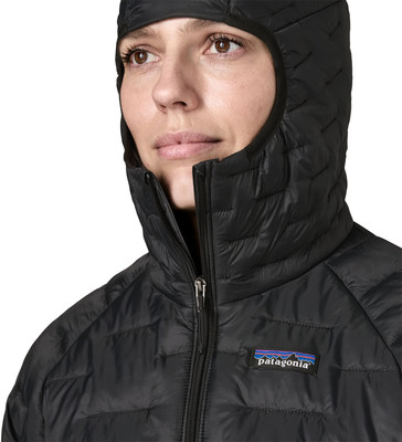 Detail einer schwarzen Damen-Daunenjacke mit Kapuze und Patagonia-Logo. Detail einer schwarzen Damen-Daunenjacke mit Kapuze und Patagonia-Logo.