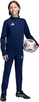 Ein Junge im dunkelblauen Trainingsanzug hält einen Fußball mit Adidas-Logo. Ein Junge im dunkelblauen Trainingsanzug hält einen Fußball mit Adidas-Logo.
