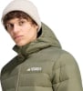 Mann in grüner Kapuzenjacke und hellbeiger Mütze.