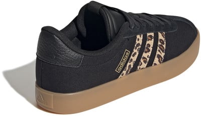 Fekete Adidas cipő leopárdmintás csíkokkal és gumitalppal.