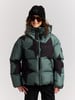 Mädchen in gesteppter Sternenjacke und schwarzer Mütze mit Brille.