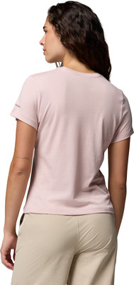 Eine Frau in einem rosafarbenen T-Shirt und beiger Hose von hinten. Eine Frau in einem rosafarbenen T-Shirt und beiger Hose von hinten.