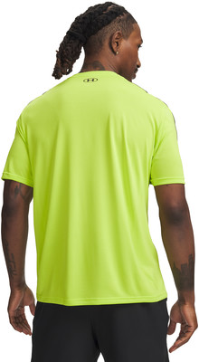 Mann in neongelbem Shirt und schwarzer Hose mit Tätowierung. Mann in neongelbem Shirt und schwarzer Hose mit Tätowierung.