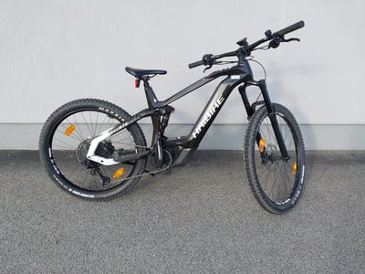 Ein schwarzes Haibike E-Mountainbike mit Federung steht vor einer Wand. Ein schwarzes Haibike E-Mountainbike mit Federung steht vor einer Wand.