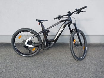 Ein schwarzes Haibike E-Mountainbike mit Federung steht vor einer Wand.