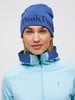 Eine Frau in einer blauen Mütze und hellblauer Kapuzenjacke.