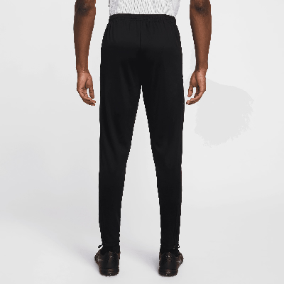 Mann von hinten in schwarzer Sporthose und Fußballschuhen. Mann von hinten in schwarzer Sporthose und Fußballschuhen.