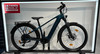 Elegantes dunkelgrünes E-Bike mit Ständer und Lichtern.