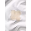 Beige Kleidungspflaster in Kleeblattform auf weißem Stoff.