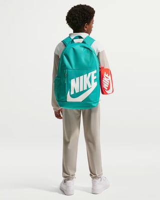 Fiú teal Nike hátizsákkal és piros tolltartóval fehér háttér előtt. Fiú teal Nike hátizsákkal és piros tolltartóval fehér háttér előtt.