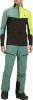 Mann in grüner Skihose und farbiger Jacke mit Logo.