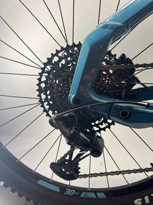 SRAM-Schaltwerk an einem blauen Fahrrad mit großer Kassette.