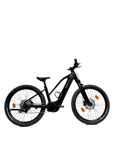 Ein schwarzes E-Mountainbike mit Federung und breiten Reifen.