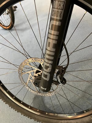 Detail eines Mountainbike-Vorderrads mit Scheibenbremse und RockShox-Federung. Detail eines Mountainbike-Vorderrads mit Scheibenbremse und RockShox-Federung.