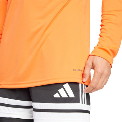 Orange Langarmshirt mit schwarzen Shorts und Adidas-Logo.