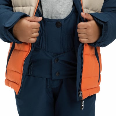 Kinder-Winterjacke mit orangefarbenen und beige Einsätzen und dunkelblauen Latzhosen. Kinder-Winterjacke mit orangefarbenen und beige Einsätzen und dunkelblauen Latzhosen.