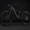 Ein schwarzes E-Bike mit Federung auf dunklem Hintergrund.