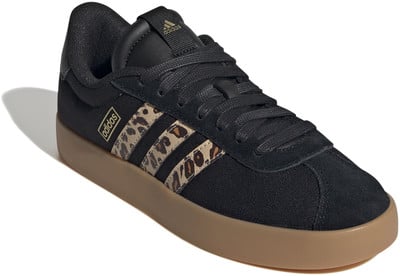 Fekete Adidas sportcipő leopárdmintás csíkokkal és barna talppal.