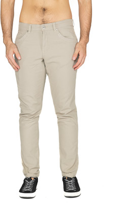 Ein Mann in beige Hosen und schwarzen Turnschuhen steht auf weißem Grund. Ein Mann in beige Hosen und schwarzen Turnschuhen steht auf weißem Grund.
