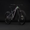 Ein E-Mountainbike mit farbigem Rahmen und Federung auf schwarzem Hintergrund.