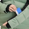 Hand steckt eine Intersport-Karte in eine Daunenjacke.