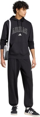 Ein Mann in schwarzer Adidas-Kleidung mit einer Umhängetasche. Ein Mann in schwarzer Adidas-Kleidung mit einer Umhängetasche.