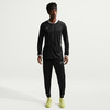 Ein Mann in schwarzer Nike Sportbekleidung mit weißen Akzenten und gelben Fußballschuhen.