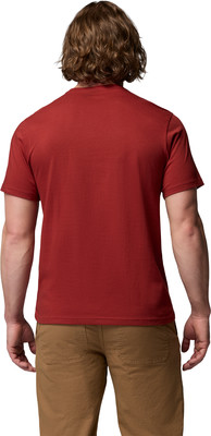 Rückansicht eines Mannes in einem roten T-Shirt und braunen Hosen.