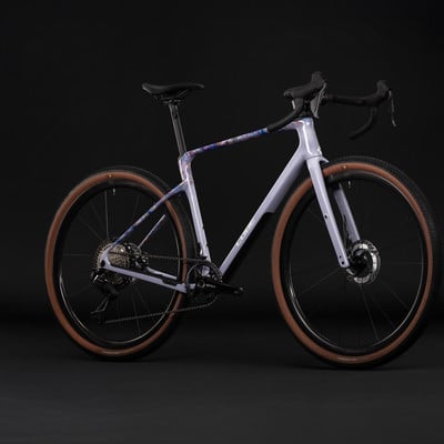 Modernes Gravelbike mit violettem Rahmen und farbigem Muster.