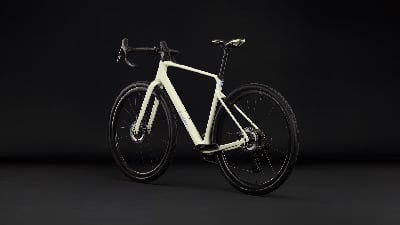 Ein hellbeige Gravelbike steht vor schwarzem Hintergrund. Ein hellbeige Gravelbike steht vor schwarzem Hintergrund.