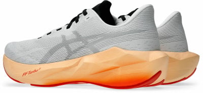 Weiße Laufschuhe mit orangefarbener Sohle und schwarzen Schnürsenkeln. Weiße Laufschuhe mit orangefarbener Sohle und schwarzen Schnürsenkeln.
