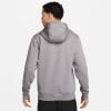 Rückansicht eines Mannes in einem grauen Kapuzenpullover und schwarzer Hose.