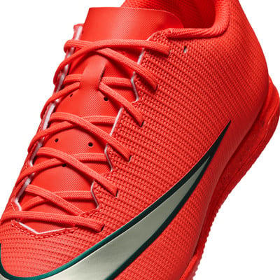 Detailný záber na červenú futbalovú obuv so šnúrkami a logom Nike. Detailný záber na červenú futbalovú obuv so šnúrkami a logom Nike.