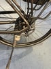 Detail des Hinterrads eines schwarzen Fahrrads mit Schaltwerk und Ständer.