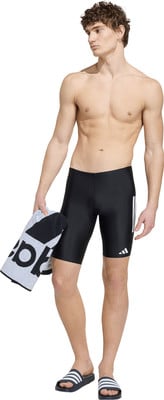 Ein Mann in schwarzer Badehose hält ein Handtuch und trägt Sandalen. Ein Mann in schwarzer Badehose hält ein Handtuch und trägt Sandalen.