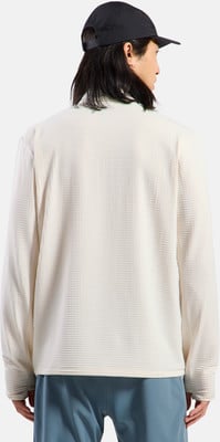 Rückansicht eines Mannes in einem cremefarbenen Langarmshirt und blauen Hosen.