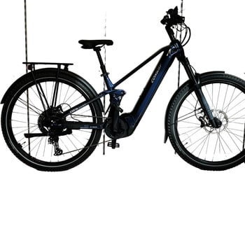 Ein blaues E-Bike mit Federung, Schutzblechen und Gepäckträger hängt vor weißem Hintergrund.